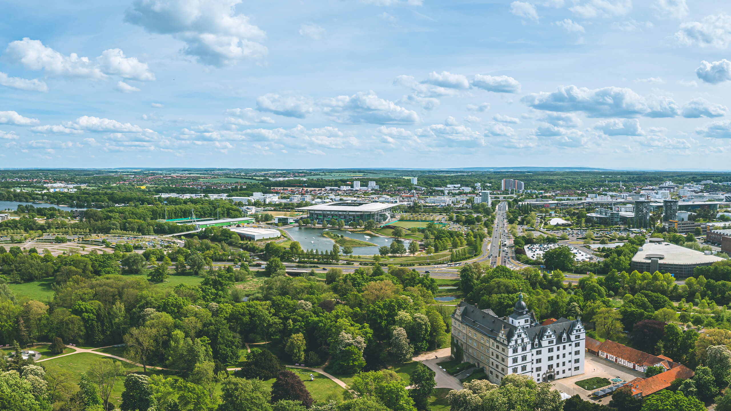 Panoramablick über die Stadt Wolfsburg mit dem Schloss, Gebäuden und viele Grünflächen