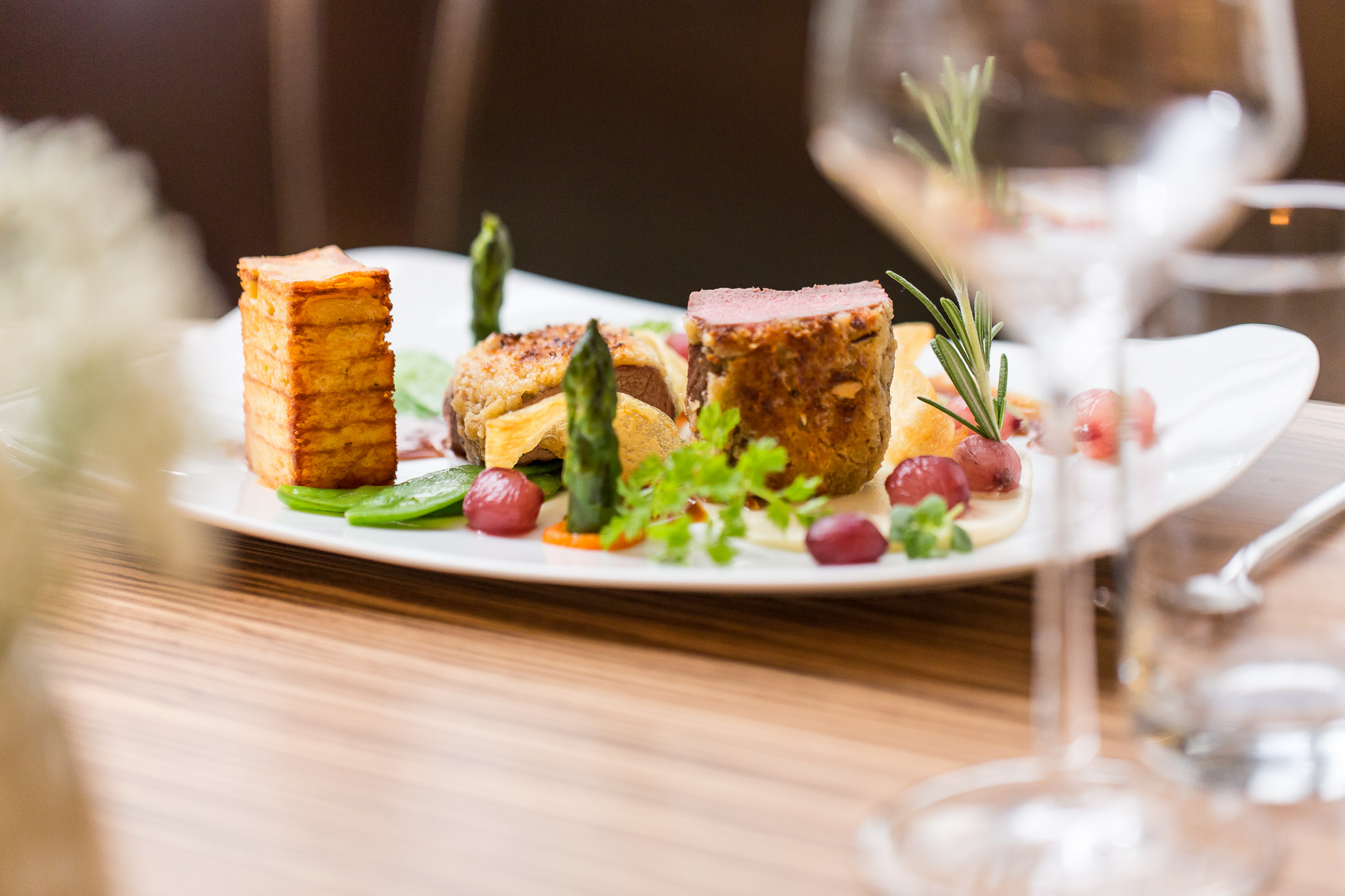 Ein Teller mit angerichteten Essen und ein Glas Wein