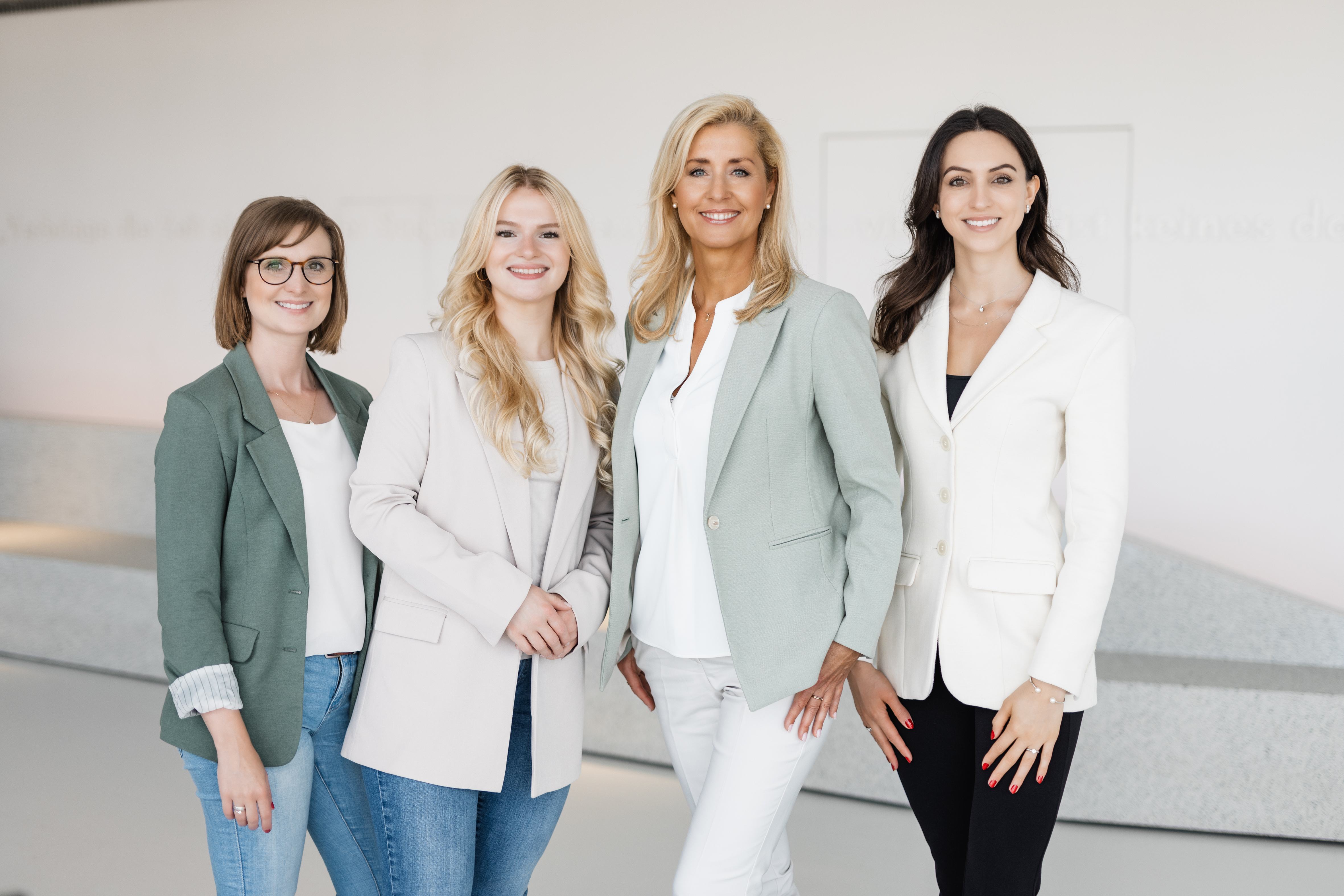 Die vier Mitarbeiterinnen des Wolfsburg Convention Bureaus vor einem hellen Hintergrund.