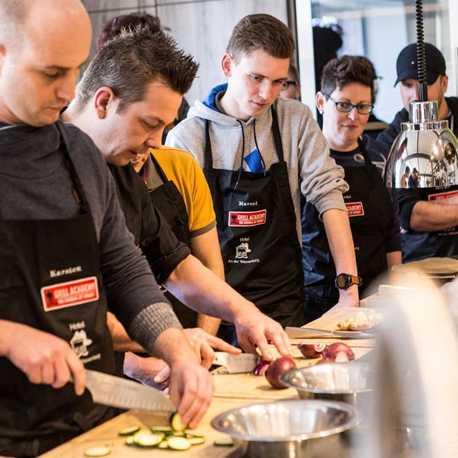 Mehrere Personen beim Zubereiten von Essen an einer Arbeitsplatte