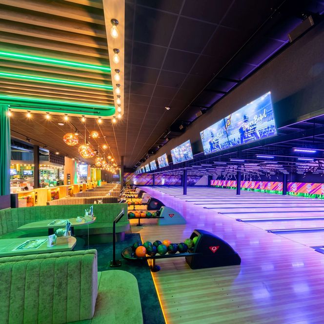 Bunt beleuchtete Bowlingbahnen mit Sitzgelegenheiten