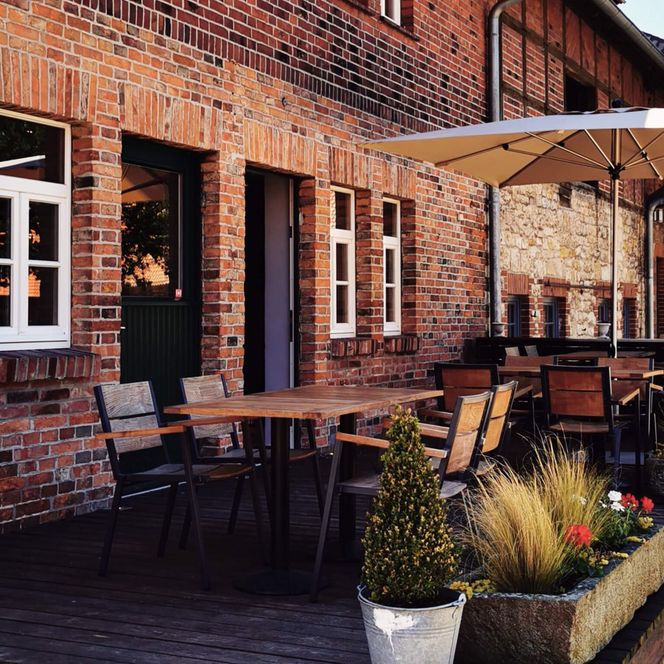 Terrasse eines alten Fachwerkhauses mit Sitzgelegenheiten