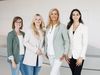 Die vier Mitarbeiterinnen des Wolfsburg Convention Bureaus vor einem hellen Hintergrund.